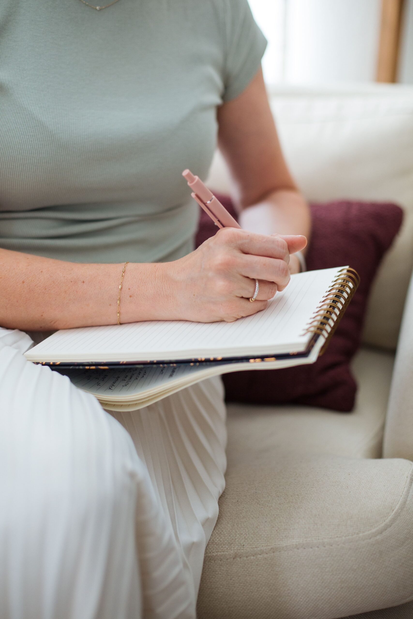 Therapist in Gilbert, AZ writing in notebook during EMDR sessions in therapy office setting.